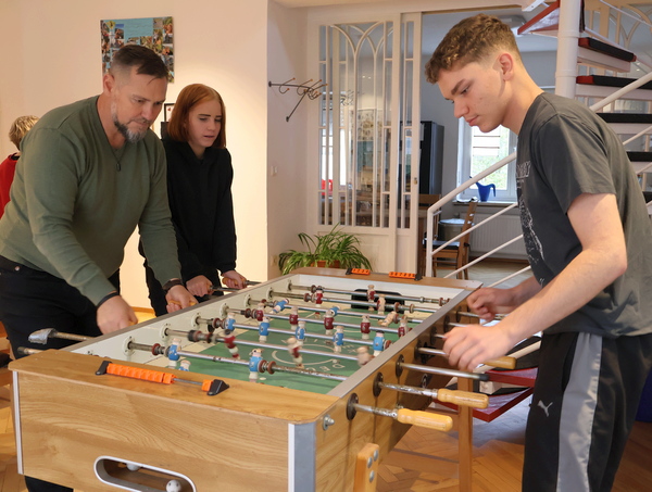 Zwei Jugendliche und ein Erzieher spielen Kicker
