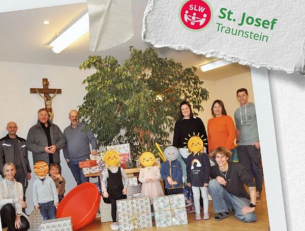 Gruppenfoto mit Kindern und Erwachsenen mit Weihnachtspäckchen vor dem Weihnachtsbaum