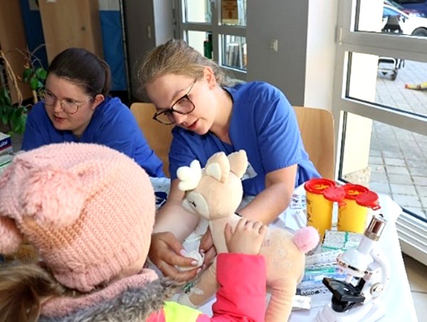Liebevoll versorgen die Pflegefachkräfte gemeinsam mit den Kindern die verletzten Kuscheltiere.