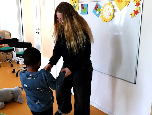 Eine Frau tanzt mit einem Jungen.